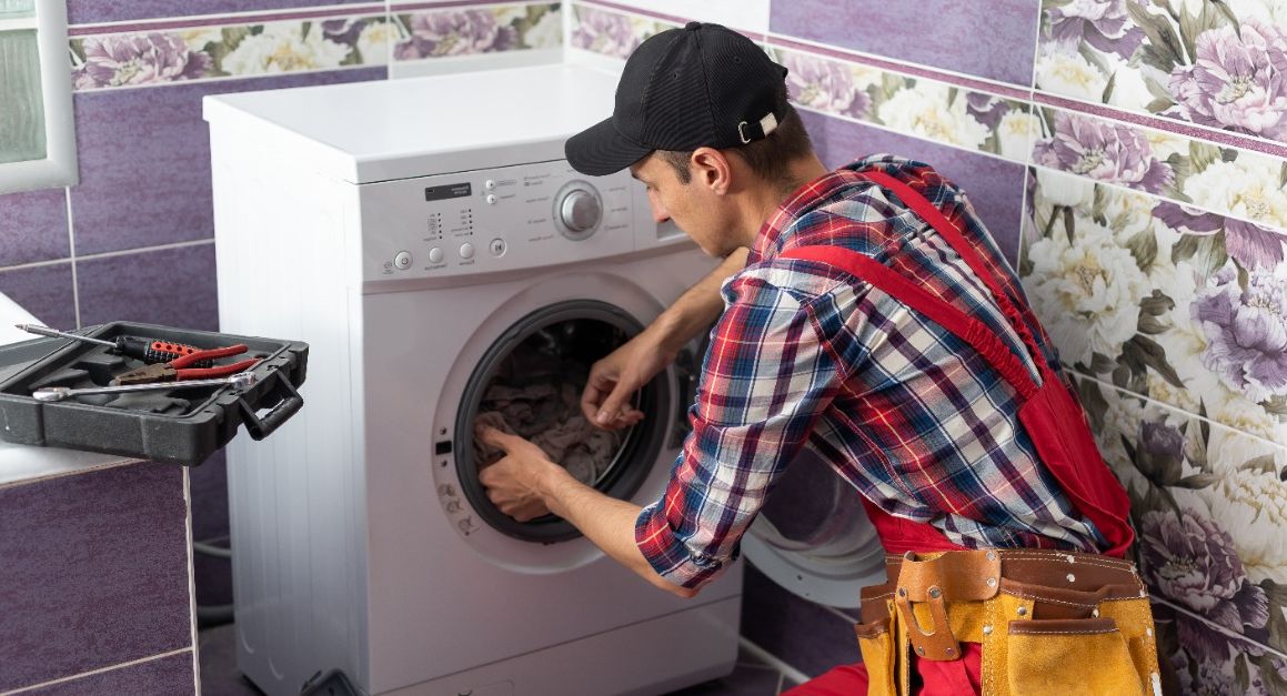 Hombre arreglando lavadora